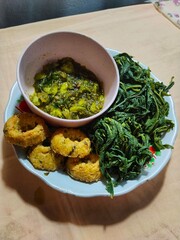 green chili sauce with boiled cassava leaves and fried tofu. A delicious simple side dish from Indonesia. green chili sauce with petai