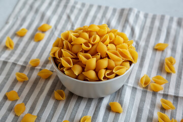 Dry Organic Medium Pasta Shells in a Bowl, side view.