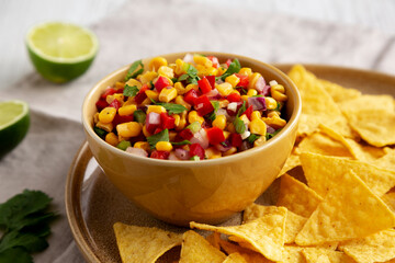 Homemade Corn Salsa with Tortilla Chips on a Plate, low angle view. Close-up.