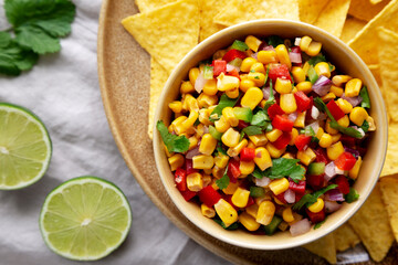Homemade Corn Salsa with Tortilla Chips on a Plate, top view. Flat lay, overhead, from above.
