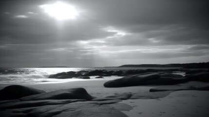 Fototapeta premium Sunlit coastal rocks and beach in monochrome.
