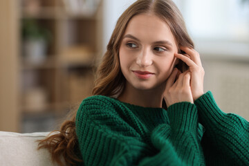 Charming young woman on sofa at home. Autumn atmosphere