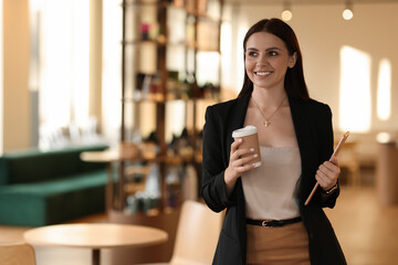 Woman in stylish formal suit with tablet and coffee indoors. Space for text