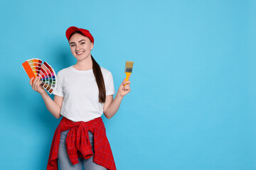 Portrait of young decorator with color palettes and brush on light blue background, space for text
