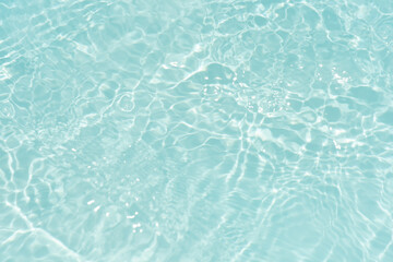 Blue water with ripples on the surface. Defocus blurred transparent blue colored clear calm water surface texture with splashes and bubbles. Water waves with shining pattern texture background.