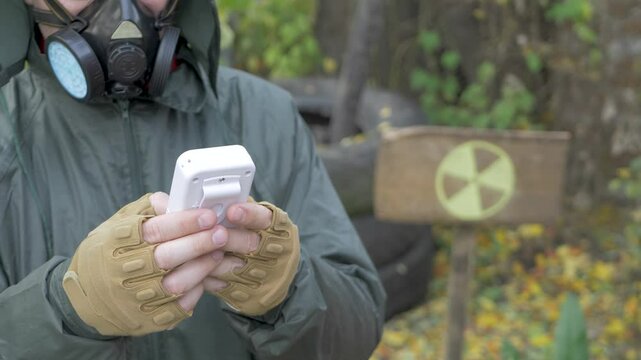 Unrecognizable inspector uses Geiger counter. International symbol background for types and levels of ionizing radiation, radioactivity, that are unsafe for unshielded humans