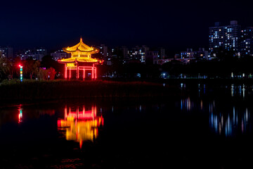 Fototapeta premium The skyline of rivers, trees, and city parks at sunset and night