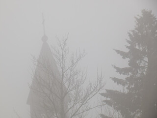 A church bell tower in the wintertime fog.
