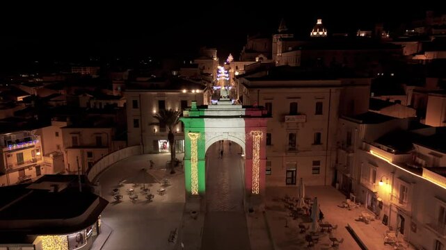 night flying over arch towards main street of Noto Sicily
