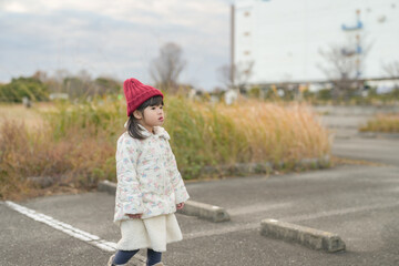 A 3-year-old Japanese girl is walking on a cold winter night through the parking lot of a seaside park in Hakata, Fukuoka Prefecture.