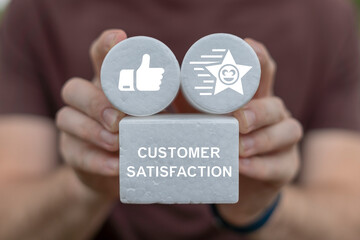 Person holding white foam blocks with icons sees inscription: CUSTOMER SATISFACTION. User give rating to service experience. Customer review satisfaction feedback survey concept.