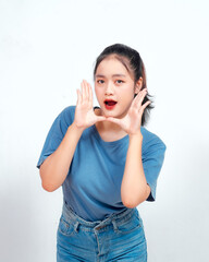 Surprised Asian woman reclines on her hands and shouting while looking at the camera over white background