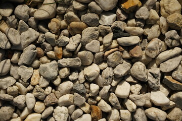 Natural gray pebbles background with various shapes.