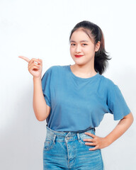 Excited Asian woman pointing at the copy space beside her, isolated on white background