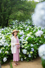 Pregnant woman in hydrangea flower farm garden