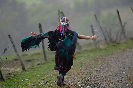 Joven etnia Mapuche, corriendo libremente en un campo con los brazos abiertos. 
