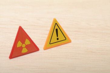 The radiation symbol warns of potential exposure to radioactive materials, while the exclamation...