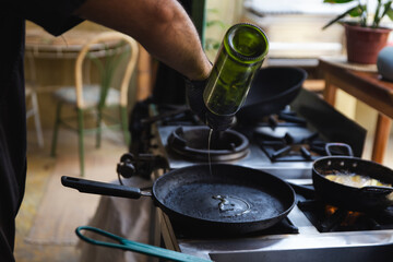 Chef putting oil on a pan for a Delicious hamburger