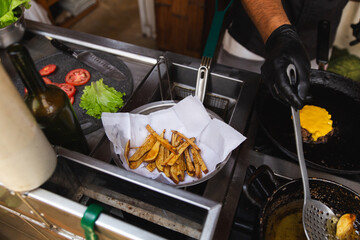 Chef frying french fries on a pan