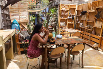 A woman enjoying a burger and fries at a beachside cafe