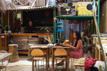 A woman Enjoying a burger and fries at a Beachside Café