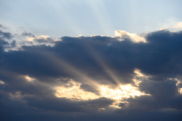 Creepy sunbeams shooting out of dark clouds, Halloween nature background
