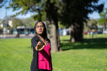 Latin transgender woman saying no with her hand. Stop concept.