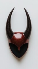 A close-up of a decorative mask resembling a demonic face with horns, encrusted with crystals and highlights the concept of fear, insecurity, and the unknown.