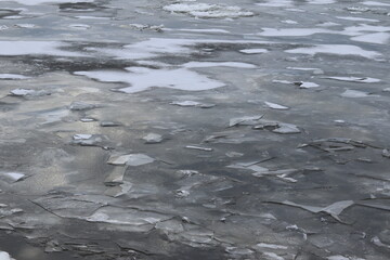 Abstract and gray background. The St-Laurent river in winter and covered in ice. Textured icebergs on water and the stream of a river.. A vast frozen river with ices.