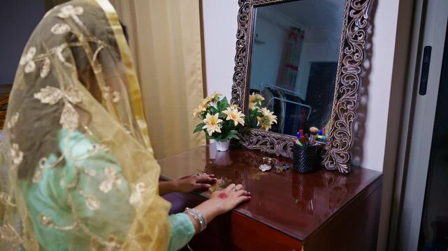 Bride sits leisurely looking in mirror on wedding night