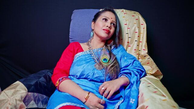 Thoughtful woman wearing saree sitting in a room