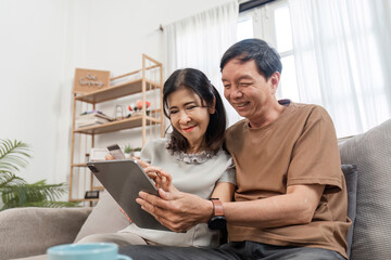 Obraz premium Elderly Couple Collaborating on Family Financial Planning with Digital Tablet at Home