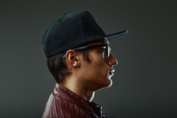 Profile of young stylish man wearing a cap and eyeglasses