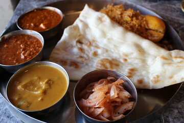 Indian cuisine: curry lunch plate (chicken keema curry, seafood curry, achar, naan and egg biryani)