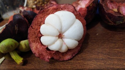 An opened tropical Asian fruit mangosteen, on a table