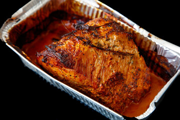 A piece of meat is sitting in a pan with a lot of seasoning on it