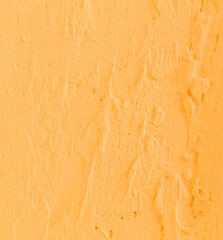 A wall with yellow paint and a textured surface