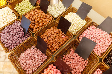 A basket of assorted nuts and seeds are displayed in a store