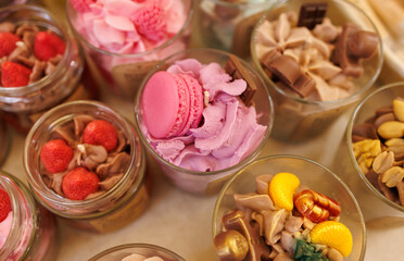 A variety of desserts are displayed in glass jars