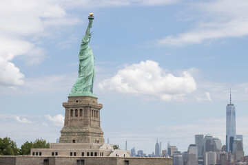 The Statue of Liberty on the Liberty Island in New York with the Manhattan skyline in the background.