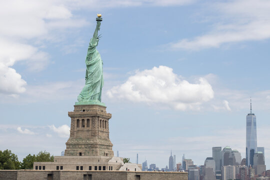 The Statue of Liberty on the Liberty Island in New York with the Manhattan skyline in the background.