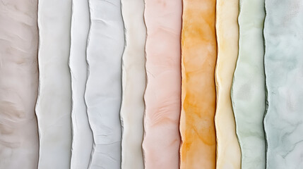 Textured paper sheets in various pastel colors arranged in row