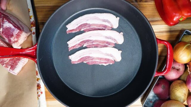 Cooking Corn Chowder for a week night meal. Preparing dinner with lots of ingredients like corn, cream, bacon, potatoes and onions.  Sizzling bacon in a skillet.