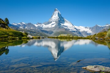 Stunning Matterhorn peak mirrored in a tranquil alpine lake. Surrounding mountains, lush green meadows, clear blue sky. Idyllic Swiss Alps scenery.