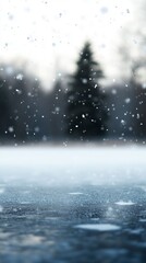 Obraz premium Snowflakes gently fall in a serene winter landscape, with a solitary evergreen tree in the soft focus background.