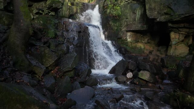 Drone view of Lumsdale falls streaming on rocks in a steep-sided gorge in Derbyshire, England