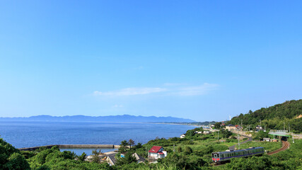 出雲の対岸から夏空の日本海と山陰本線の気動車を望む