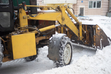 Heavy machinery on the street in winter. Snow removal with a bucket.