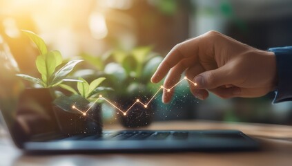 Hand tracing upward graph above laptop.