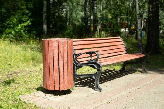 Shop in park. Bench and trash can made of wood.